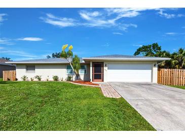 Charming single-story home with a well-maintained lawn and a sunny, blue sky at 1049 Presque Isle Dr, Port Charlotte, FL 33952