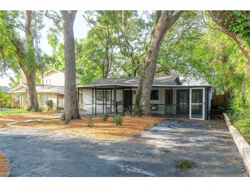 Charming single-story home with mature trees and a cozy, screened-in porch area at 709 1St Ne Ave, Largo, FL 33770