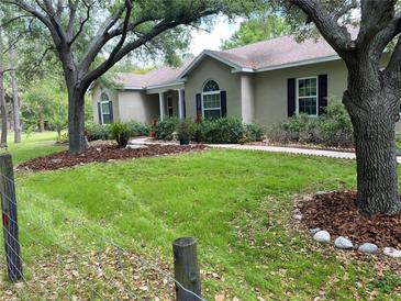 Charming single-story home with a well-manicured lawn, mature trees and flowerbeds enhancing the property's curb appeal at 10533 Hazel St, Largo, FL 33778