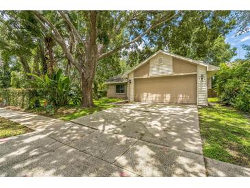 Charming home featuring a two-car garage, neutral color scheme, and mature trees providing ample shade at 2002 Culpepper Dr, Brandon, FL 33511
