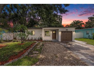 Charming home featuring a well-manicured lawn, quaint walkway, and attached one car garage at 6208 S Harold Ave, Tampa, FL 33616