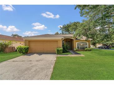 Charming single-story home featuring a lush green lawn and mature trees under a partly cloudy sky at 1236 Sweet Gum Dr, Brandon, FL 33511