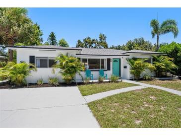 Charming single-story home with lush landscaping, a turquoise door, and a modern design at 707 63Rd S Ave, St Petersburg, FL 33705