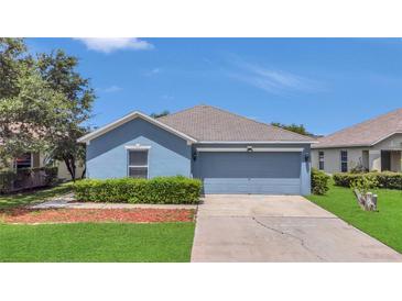 Charming blue single-story home with a well-manicured lawn and a two-car garage at 5145 Prairie View Way, Wesley Chapel, FL 33545