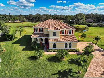 Stunning two-story home featuring a tile roof, lush landscaping, and a brick driveway at 7315 Bianco Duck Ct, Sarasota, FL 34240