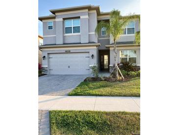 Two-story house with gray exterior, landscaping, and driveway at 3101 Hollow Hickory Pl, Wesley Chapel, FL 33543