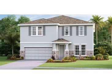 Two-story house with gray siding, stone accents, and a two-car garage at 7479 Rome Ln, Brooksville, FL 34613