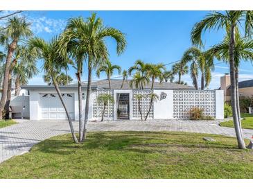 Charming single-story home with mature palm trees and a neatly paved driveway, perfect for coastal living at 193 Mar St, St Pete Beach, FL 33706