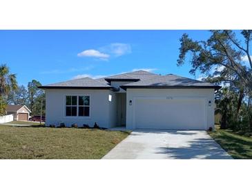 Charming single-Gathering home with a well-manicured lawn and a two-car garage at 2576 Pecan St, North Port, FL 34287