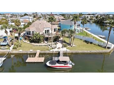 Waterfront home featuring tropical landscaping, a private dock, and easy access to the canal at 4446 Bahama Dr, Hernando Beach, FL 34607