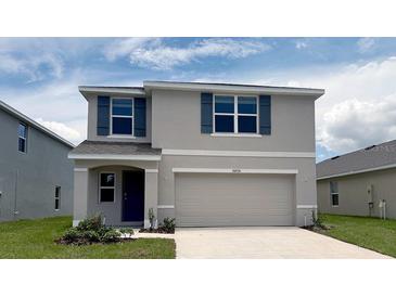 Charming two-story home with a two-car garage and beautiful blue shutters in a well manicured lawn at 30926 Silver Stage Dr, Brooksville, FL 34602