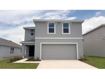Charming two-story home featuring a two-car garage and a well-manicured lawn at 30934 Silver Stage Dr, Brooksville, FL 34602