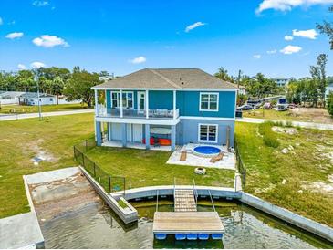 Backyard featuring a private dock, jacuzzi, and outdoor space with a waterfront view at 6771 Seaview Blvd, Hudson, FL 34667