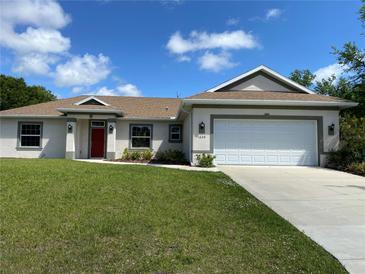 Charming single-Gathering home with a well-manicured lawn and a two-car garage on a sunny day at 1608 Alliance Ave, North Port, FL 34286