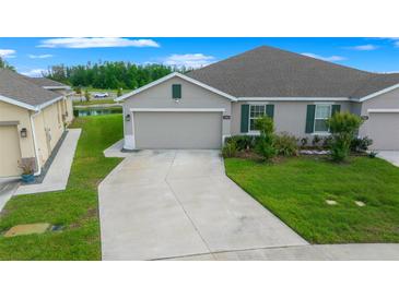 Charming single-story home with a well-manicured lawn and attached two-car garage at 17663 Turning Leaf Cir, Land O Lakes, FL 34638