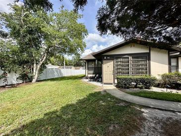 Cozy home featuring a well-maintained lawn and a charming walkway leading to the front door, surrounded by lush greenery at 4622 Blossom Blvd # D, Zephyrhills, FL 33542