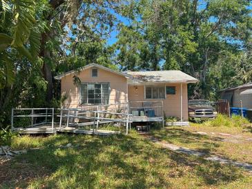 Exterior view of a single-story home with a ramp and overgrown landscaping at 665 36Th S Ave, St Petersburg, FL 33705
