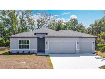 Charming single-story home featuring a three-car garage and beautifully landscaped front yard at 1696 Bendix Ter, North Port, FL 34286