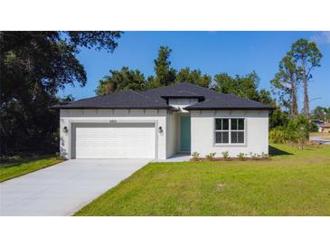 Charming single-Gathering home with well-manicured lawn, attached garage, and a lovely light-blue front door at 2423 Sadnet Ln, North Port, FL 34286