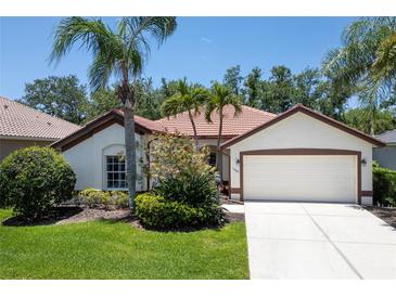 Charming single-story home boasts lush landscaping, a two-car garage, and a clay tile roof at 3389 Pennyroyal Rd, Port Charlotte, FL 33953