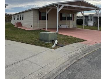 Tan-sided single-story home with a carport, offering covered parking and easy access at 8343 Fantasia Park Way, Riverview, FL 33578