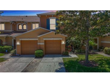 Charming townhome featuring a two-car garage, landscaped front yard, and neutral exterior paint at 4510 Limerick Dr, Tampa, FL 33610