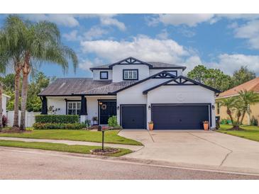 Charming two-story home featuring a two-car garage, manicured lawn, and beautiful landscaping at 205 Bengal Cir, Oldsmar, FL 34677