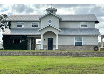 Charming two-story home with a metal roof and well-maintained landscaping, exuding curb appeal at 15200 Rawls Rd, Sarasota, FL 34240
