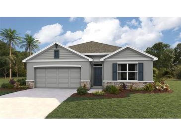 Charming single-Gathering home featuring a two-car garage, manicured lawn, and stone accents at 10434 Tucker Rd, Weeki Wachee, FL 34613