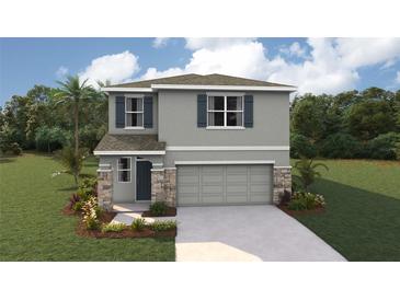 Two-story home featuring stone accents, gray siding, shutters, landscaped yard, and a two-car garage at 10484 Tucker Rd, Weeki Wachee, FL 34613