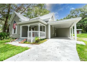 Charming home featuring a welcoming front porch, carport, and well-maintained landscaping at 304 Highland St, Brooksville, FL 34601