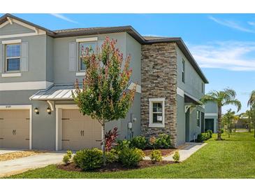 Charming townhome with a stone facade, well-maintained landscaping, and an attached two-car garage at 14347 Easy Goer St, Ruskin, FL 33573