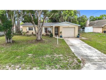 Charming single-story home featuring a well-manicured lawn and a one-car garage at 7318 Tranquil Dr, Spring Hill, FL 34606
