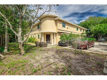 Tan two-story home with a unique rounded front and landscaping at 6628 1St N St, St Petersburg, FL 33702
