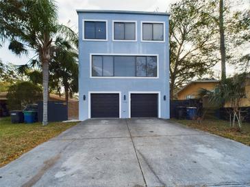 Modern two-story home with a two-car garage and palm tree in the front yard at 1793 N Fort Harrison Ave, Clearwater, FL 33755