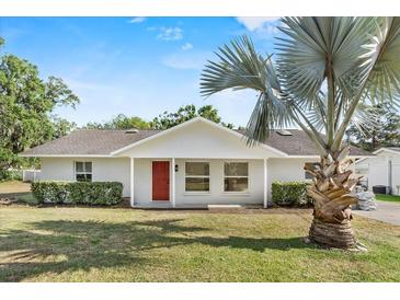 Charming single-story home featuring a bright red front door and lush lawn at 1103 W Dixie St, Plant City, FL 33563