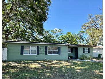 Charming single-story home featuring a well-maintained lawn, traditional windows with shutters, and mature shade trees at 1808 Heather Ave, Tampa, FL 33612
