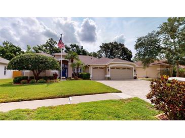 Inviting single Gathering home featuring a well-manicured lawn, a spacious three-car garage, and charming landscaping at 4506 Gentrice Dr, Valrico, FL 33596