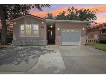 Charming single-Gathering home featuring a one-car garage, a stucco exterior, and a cozy front porch at 6621 La Mesa Rd, Land O Lakes, FL 34637