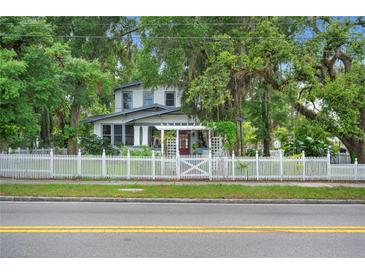 Charming two-story home with a white picket fence and mature trees at 1007 N Wheeler St, Plant City, FL 33563