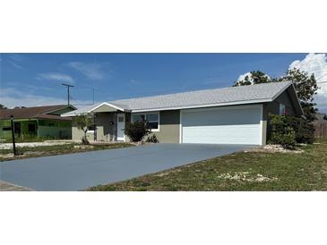 Charming single-Gathering home featuring a neatly painted exterior, gray roof, and a convenient two-car garage at 1735 Council Dr, Sun City Center, FL 33573