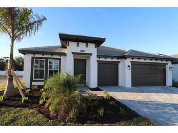 Beautifully landscaped modern home with a two car garage and neutral color palette at 1744 Lugano Cir, North Venice, FL 34275