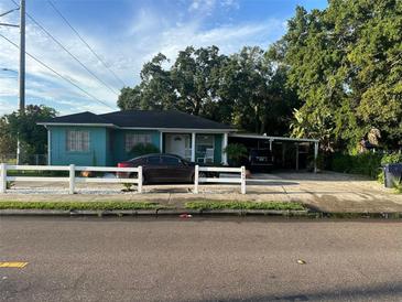 Quaint teal home with carport and white picket fence at 2415 E 21St Ave, Tampa, FL 33605