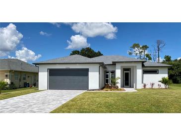 Modern one-story home with gray garage door and gray trim at 23466 Garrett Ave, Port Charlotte, FL 33954