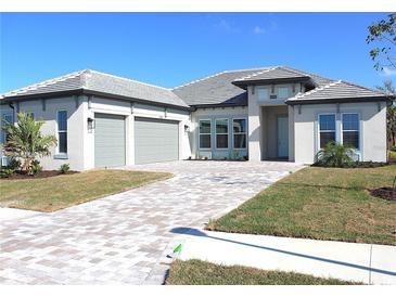 Beautiful single-story home featuring a paver driveway, two-car garage, and well-manicured landscaping at 13378 Amargo Ct, Venice, FL 34293