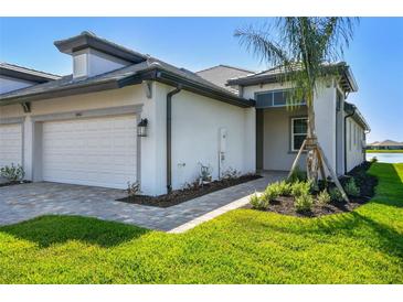 Charming villa featuring a two-car garage, paver driveway, and professionally landscaped yard at 18063 Cherished Loop, Bradenton, FL 34211
