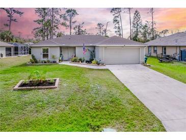 Charming single-story home featuring a well-manicured lawn and a two-car attached garage at 18149 Dillon Ave, Port Charlotte, FL 33954