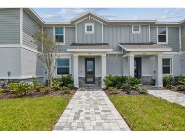 Charming townhouse exterior with gray siding, stone accents, and a well-manicured front yard at 1755 Spreader Ln, Sarasota, FL 34240