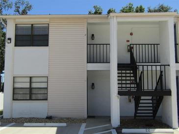 Two-story condo complex featuring neutral toned siding and an entrance area with stairs to the second level at 3102 W Horatio St # 21, Tampa, FL 33609