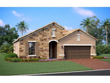 Charming one-story home featuring a stone facade, arched entryway, and well-manicured lawn at 17208 Savory Mist Cir, Bradenton, FL 34211